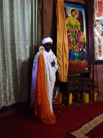 A priest presenting the cross with his sunglasses on